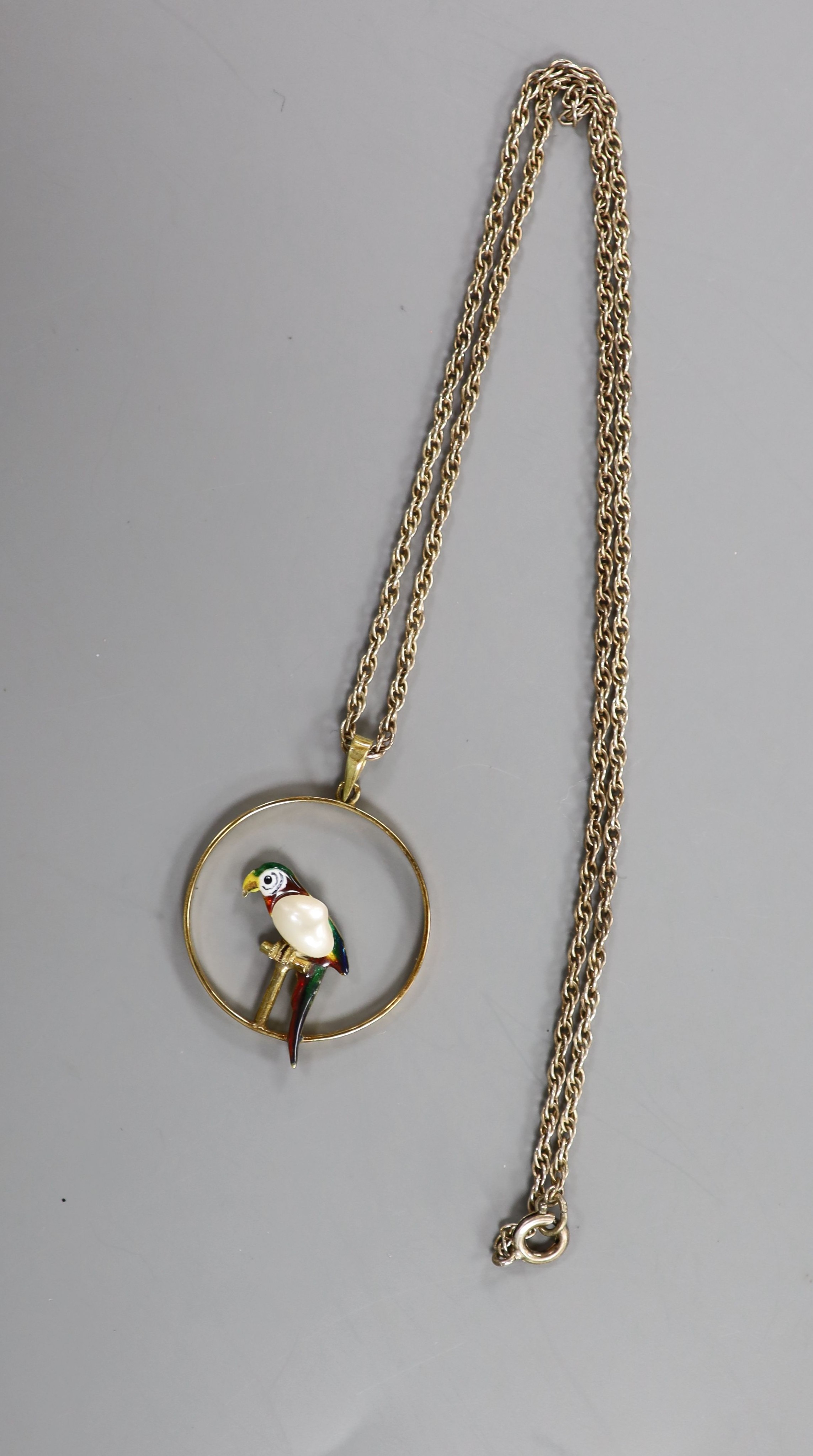 An early 20th century 15ct, enamel and baroque pearl set open work circular pendant, 22mm, gross 2.4 grams, on a later sterling chain.